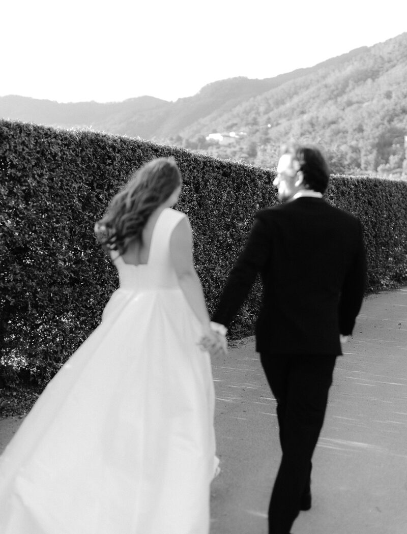 casale-de-pasquinelli-wedding-frankie-and-marilia-69 out of focus image of couple walking at the gardens at casale de pasquinelli, a wedding venue in lucca, tuscany