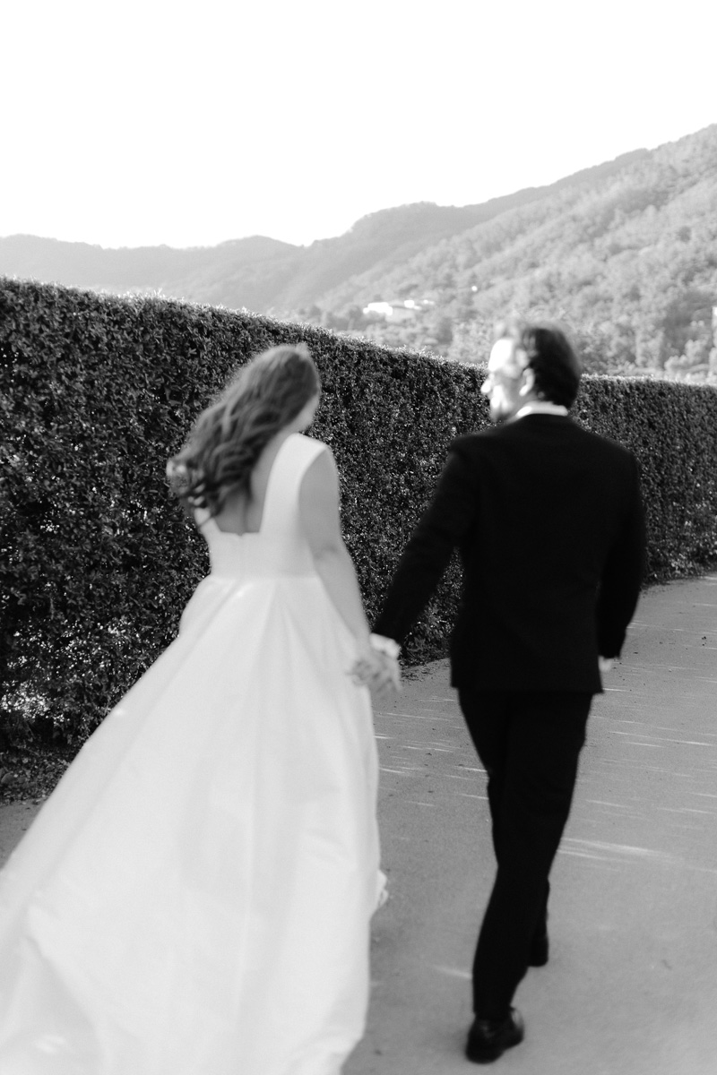 casale-de-pasquinelli-wedding-frankie-and-marilia-69 out of focus image of couple walking at the gardens at casale de pasquinelli, a wedding venue in lucca, tuscany