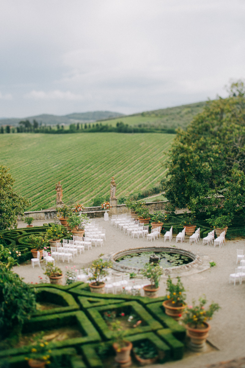 Outdoor wedding ceremony setup in the garden of Villa Corsini with Tuscan vineyard views