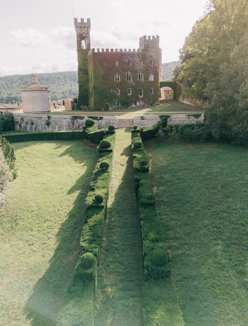castello-di-celsa-wedding-photographer-1 Aerial view of the side garden leading to Castello di Celsa, with the castle in the background.
