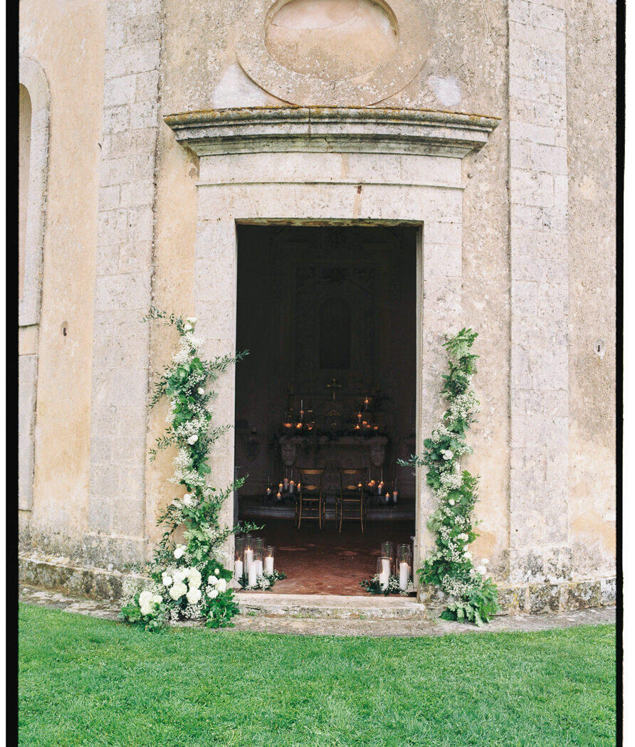 castello-di-celsa-wedding-photographer-7 Chapel entrance with floral arch (film frame): Chapel entrance at during this Castello di Celsa Wedding decorated with flowers for a wedding ceremony